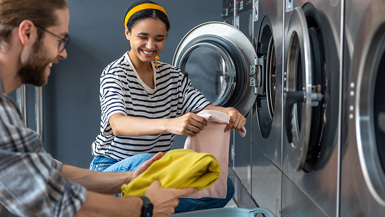 Couple in self-service laundromat doing their laundry