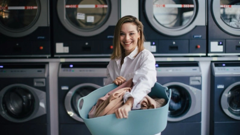 Young woman posing in a laundry room.