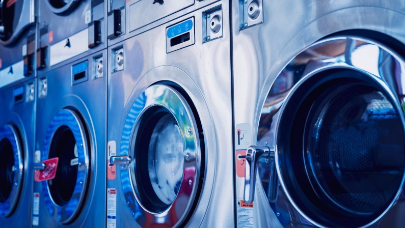 Rows of industrial laundry machines in the large laundromat.