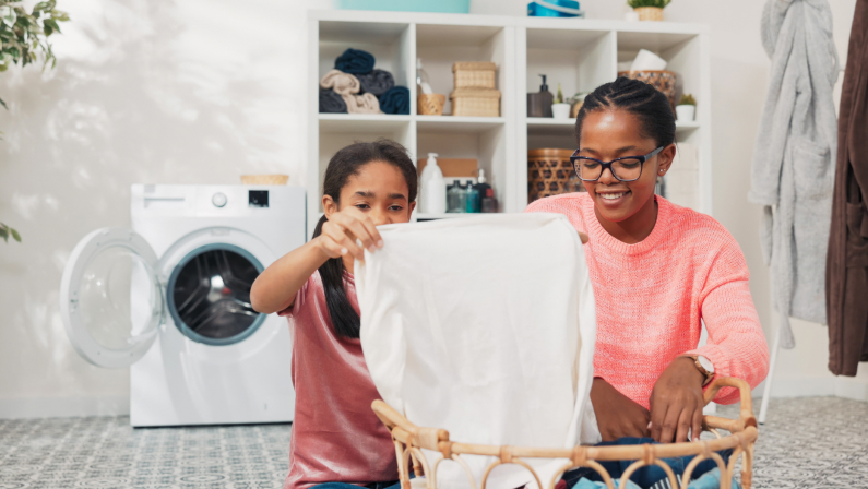 The daughter helps mother with household chores, the women sort laundry, fold clothes, prepare them for drying, they spend time together in the bathroom talking smiling
