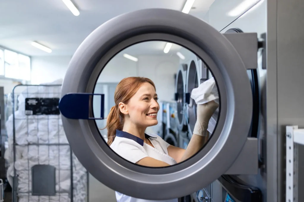 female laundry worker standing by industrial
