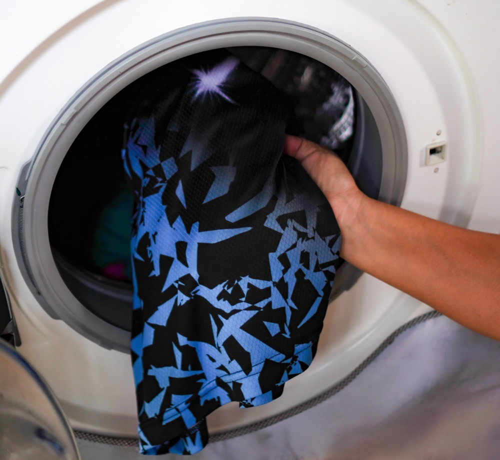 Loading Sportswear into Washing Machine Close Up