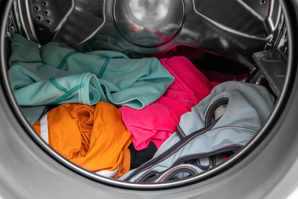 Dirty, used sportswear in a washing machine a sportswear laundry concept.